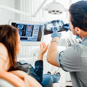 a dentist showing a patient her X-rays