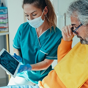 Dentist and man looking at X-rays