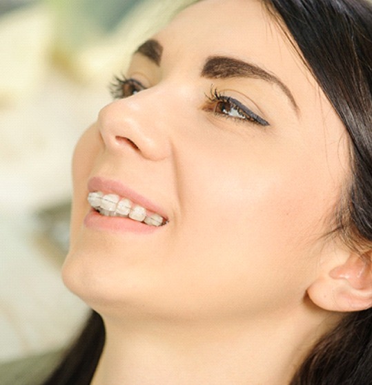 patient with clear braces reclining in dental chair