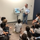 Dentist presenting to kids in a classroom
