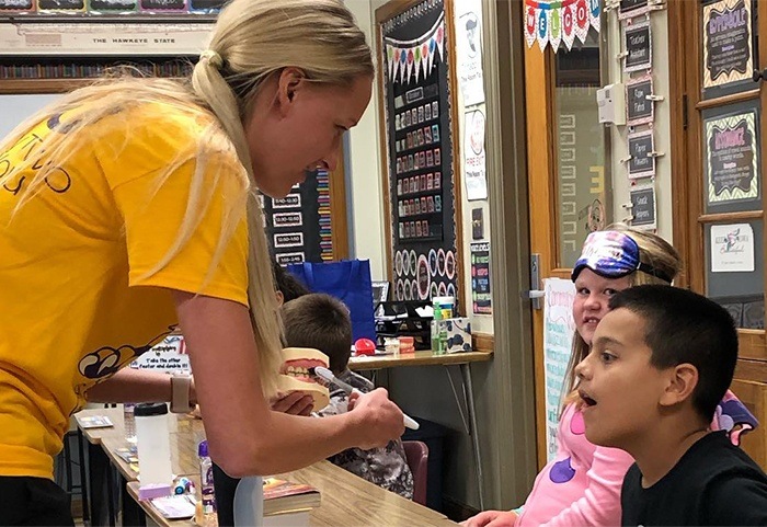 Team member showing kids how to brush