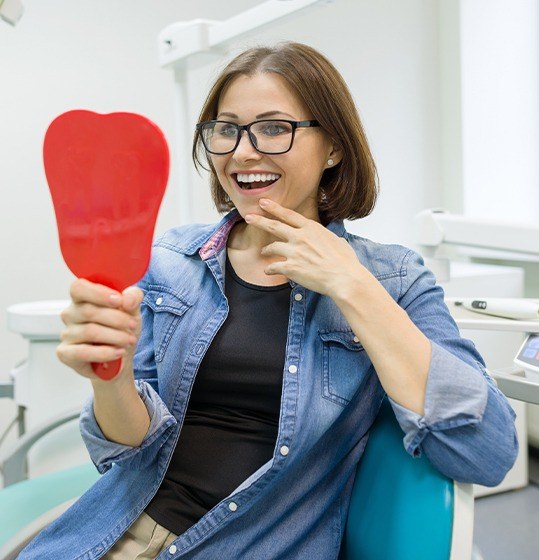 Woman looking at smile in mirror