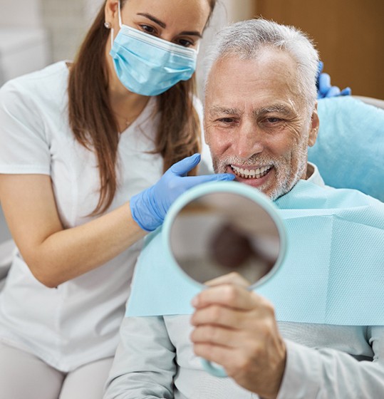 man smiling in dental mirror 