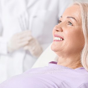 woman smiling while sitting in dental chair