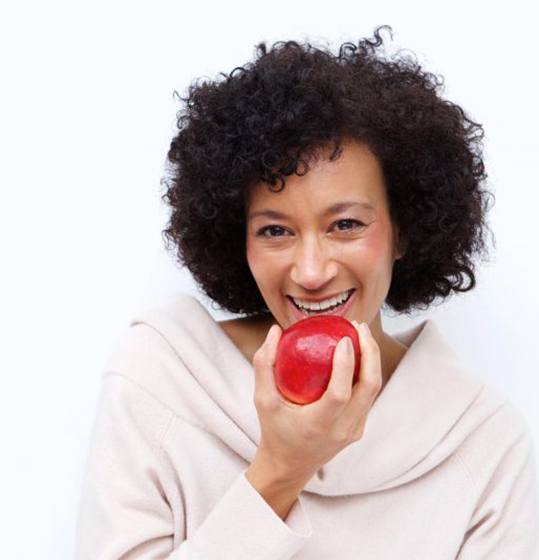 woman biting into red apple