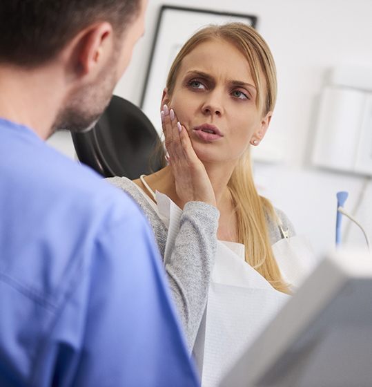 Woman with toothache holding jaw