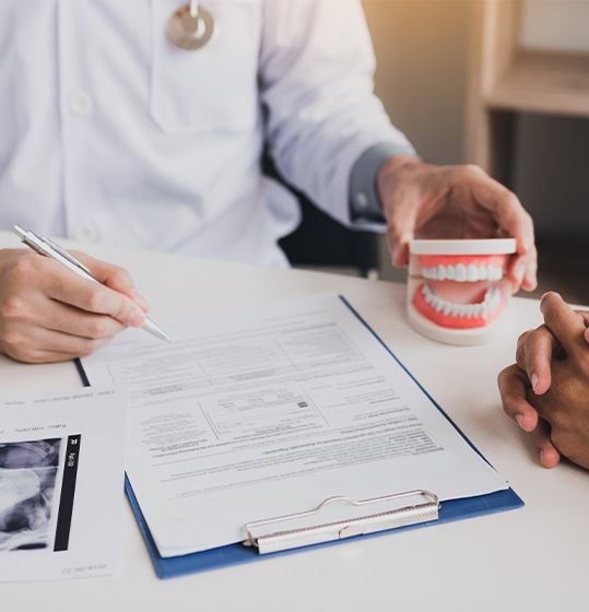 Dentist reviewing chart with dental patient