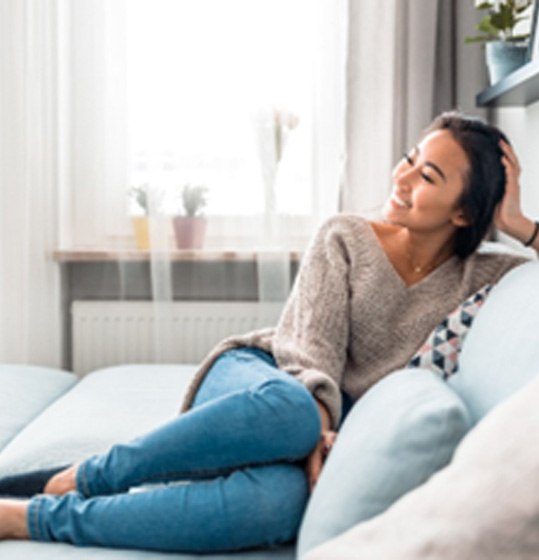 Smiling woman relaxing on couch at home