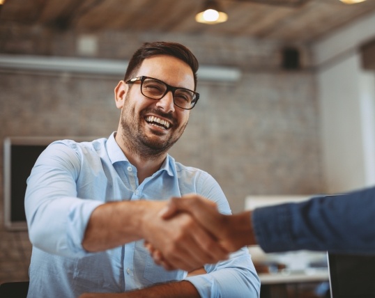 Man shaking hands with dental team member