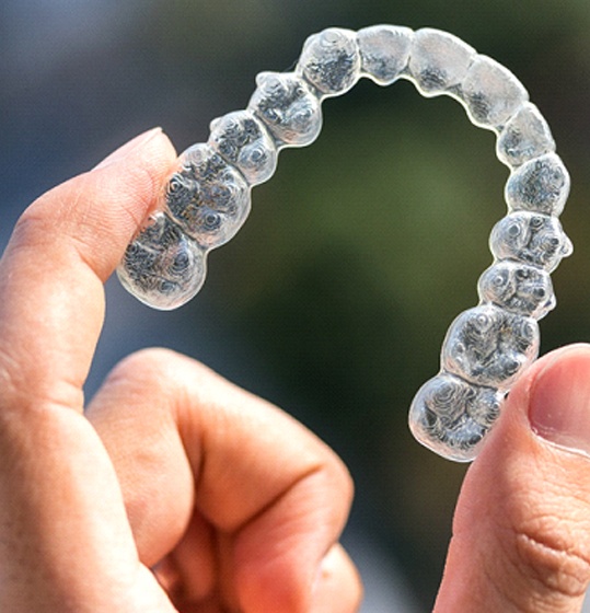 hand holding Invisalign aligner