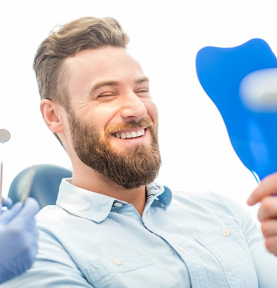 A man admiring his smile makeover results