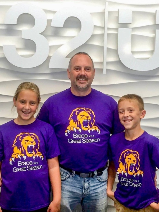 Dr. Bygness and two kids smiling in dental office