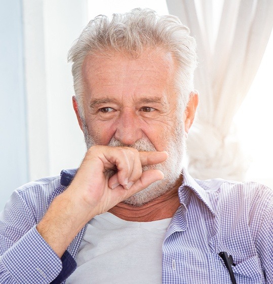 Man in need of replacement teeth hiding his smile