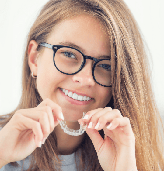 Teen girl placing Invisalign tray