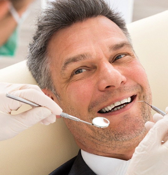 Man smiling at dentist in Denison after root canal therapy