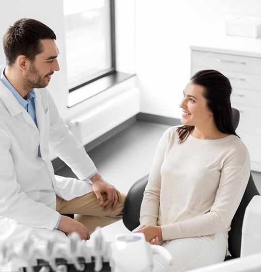 Dentist and patient smiling in dentist's office