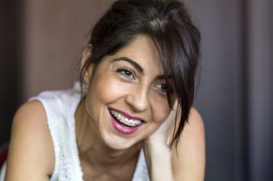 A woman in braces before seeing an emergency orthodontist in Denison