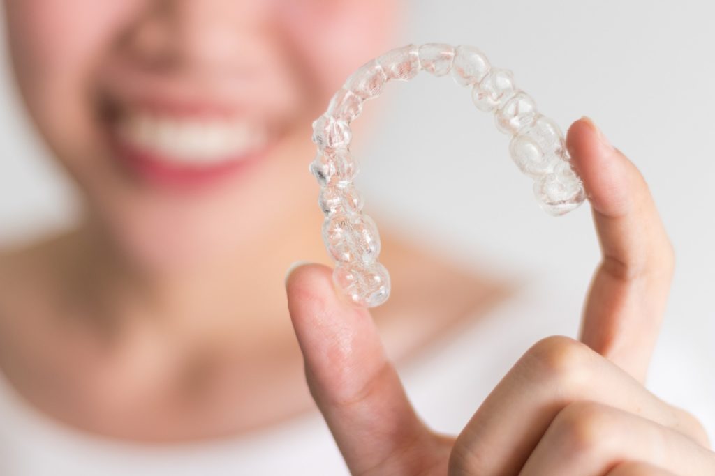 Patient holding up Invisalign aligner