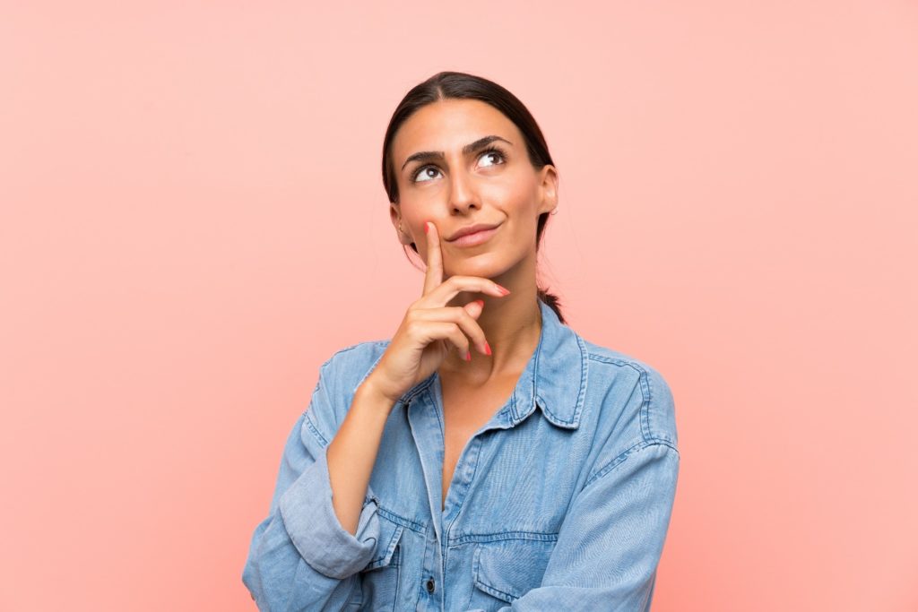 Woman in denim shirt wondering