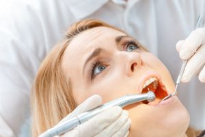 woman looking scared at dentist